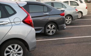 backs of cars in an open parking lot