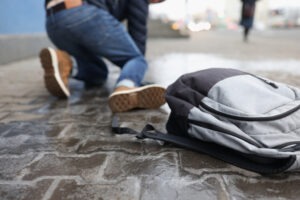 man tripping and dropping backpack