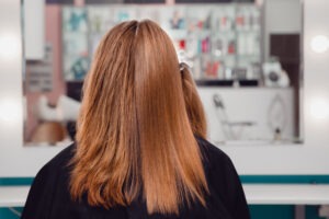 woman getting hair chemically straightened