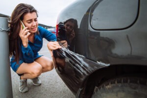 woman-standing-near-scratched-car