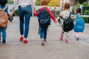 kids holding hands going into school