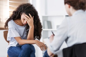 young sad woman talking to therapist