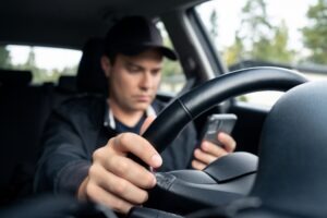 man texting while driving
